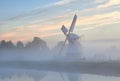 Dutch windmill in morning fog at sunrise Royalty Free Stock Photo