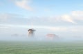 Dutch windmill in morning fog Royalty Free Stock Photo