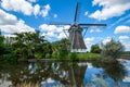 Dutch windmill reflected in the water and cloudy blue sky. Royalty Free Stock Photo