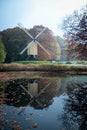 Dutch post windmill with reflection in the water