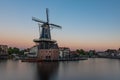 Dutch windmill, in the town of Haarlem, at sunset. The water is smooth, due to a long shutter speed Royalty Free Stock Photo