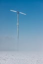 Dutch winter landscape with ground fog and wind turbine Royalty Free Stock Photo