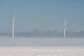 Dutch winter landscape with highway, ground fog and wind turbines Royalty Free Stock Photo