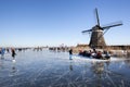 Dutch winter landscape with Ice skaters and a windmill Royalty Free Stock Photo