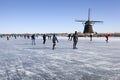 Dutch winter landscape with Ice skaters and a windmill Royalty Free Stock Photo