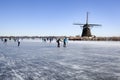 Dutch winter landscape with Ice skaters and a windmill Royalty Free Stock Photo