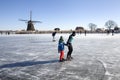 Dutch winter landscape with Ice skaters and a windmill Royalty Free Stock Photo