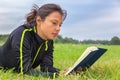 Dutch woman lying in grass reading book Royalty Free Stock Photo