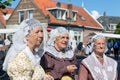Dutch women with traditional clothing and headgear at local fair