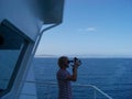 Working with sextant on merchant ship at sea