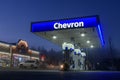 Illuminated blue awning with Chevron gas company text ar night