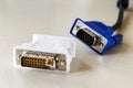 Dvi-d socket of white adapter for blue vga socket monitor cord behind it. Connection of computer devices with plugs of different