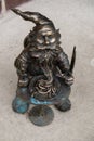 Dwarf eats pasta near restaurant. Small bronze figures of gnomes on the streets of Wroclaw. Europe Miniature bronze