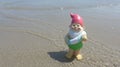 Funny garden gnome with floating ring seaside