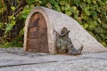 Dwarf guards the entrance of a small building