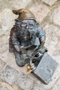 Dwarf with a padlock near bridge. Small bronze figures of gnomes on the streets of Wroclaw. Europe Miniature bronze