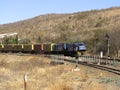 A heavily loaded goods train passes through Lobatse threading its way through its massive hills.