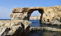 DWEJRA, GOZO, MALTA - Oct 11, 2014: The Azure Window, natural arch formed by sea cliff erosion in Gozo, and swimmers close to it Royalty Free Stock Photo