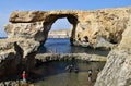 DWEJRA, GOZO, MALTA - Oct 11, 2014: The Azure Window, natural arch formed by sea cliff erosion in Gozo, and swimmers close to it Royalty Free Stock Photo