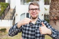 Dwelling, buying home, real estate and ownership concept - handsome man showing his key to new home Royalty Free Stock Photo