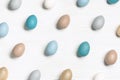 Dyed colorful Easter eggs blue, beige, neutral color, festive chicken egg as pattern on white wood background. Holiday