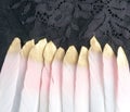 Dyed pink gilded gold golden feather isolated on black lace background Royalty Free Stock Photo