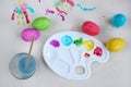 Dyeing easter eggs. Paints, palette, brush, water bowl and colored eggs on table, flat lay Royalty Free Stock Photo