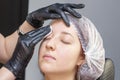 Dyeing and eyebrow shaping. girl in a beauty salon. rubbing eyebrows with alcohol