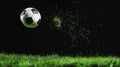 Dynamic Black and White Soccer Ball in Mid-Air with Grass Blades Exploding from Impact Against a Striking Black Royalty Free Stock Photo