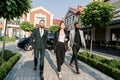 Dynamic Business team, Caucasian woman and man, African man, hurry to outdoor meeting, black car and modern office Royalty Free Stock Photo