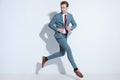 Dynamic businessman jumping and unbuttoning blue suit Royalty Free Stock Photo