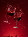 Dynamic Collision of Red Wine Glasses with Vivid Splashes Against Dark Red Background Royalty Free Stock Photo