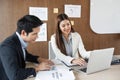 Collaborative Financial Review. Two business professionals reviewing and discussing performance metrics in a modern