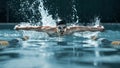 Dynamic and fit swimmer in cap breathing performing the butterfly stroke Royalty Free Stock Photo