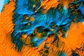 Dynamic fluid color paint splashes background. Blue and orange mixed liquid backdrop. Abstract marbling effect. Dynamic fluid