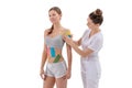 dynamic functional bandage with taping. female specialist glues kinesio tapes on the shoulder of woman Royalty Free Stock Photo