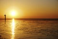 Dynamic golden sunset behind low hanging clouds over the north sea at the Dutch coast. Golden color, The Wadden Sea is a Royalty Free Stock Photo