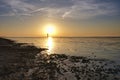 Dynamic golden sunset behind low hanging clouds over the north sea at the Dutch coast. Golden color, The Wadden Sea is a Royalty Free Stock Photo