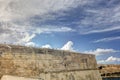 Dynamic HDR photo of cloudy skies and sun behind the clouds and historic city Valletta Royalty Free Stock Photo