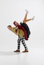 Dynamic image of stylish young couple, man and woman in retro themed clothes dancing isolated over white studio