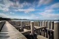 Dynamic moving white clouds against a blue sky above a wooden seahorse near a lake Royalty Free Stock Photo