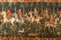 A dynamic painting depicting a collection of individuals riding on horses, A medieval hunting party, complete with hounds and