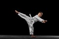 Dynamic portrait of little boy, young karate training alone isolated over white background. Concept of sport, education Royalty Free Stock Photo