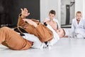 Dynamic portrait of man, professional judo, jiu-jitsu coach training with little boy, child in white kimono. Sportive Royalty Free Stock Photo