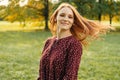 Dynamic portrait of a red head cheerful woman turning her head to the camera.