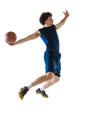 Dynamic portrait of young man, basketball player playing basketball isolated on white background. Concept of sport