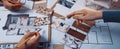 Creative Collaboration in Interior Design with Hands Examining Color Palettes and Layouts on a Table Covered with Design Royalty Free Stock Photo