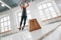 Dynamic shot of fitness male athlete jumping through at square box in cross gym Royalty Free Stock Photo