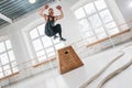 Dynamic shot of fitness male athlete jumping through at square box in crossfit gym Royalty Free Stock Photo