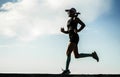 Dynamic silhouette of young attractive and athletic woman in compression running socks jogging happy on city park doing intervals